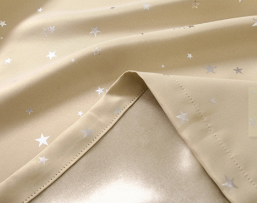 Blue star print curtains tied back to reveal sheer white curtains, in a bright room with a white chair. - Image 6