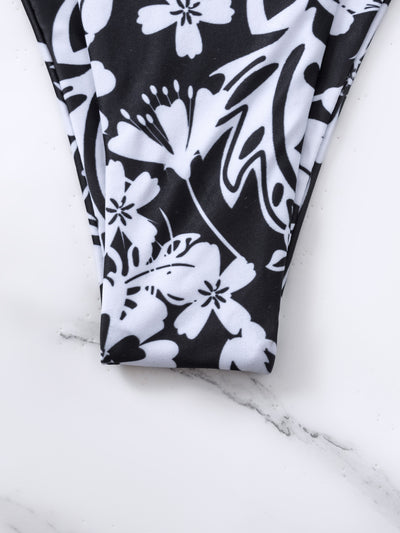 Woman wearing a black and white floral print triangle cup bikini swimsuit on a sunny beach. - Image 14