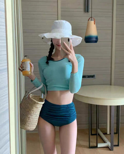 Woman in a pink long-sleeved crop top and black high-waisted ruched swim bottoms, posing in a mirror. - Image 11