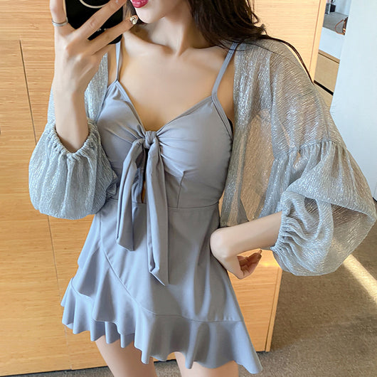 Women's light blue one-piece swimsuit with tie-front bust and ruffled hem, paired with a sheer shimmery cover-up. - Image 2