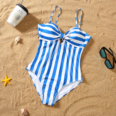 Blue and white striped one-piece swimsuit with a bow detail on the bust, laid on sand with sunglasses. - Image 4