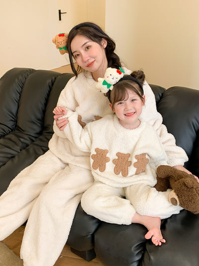 Mother and child in matching off-white coral velvet pajamas with brown cartoon bears, sitting on a black couch. - Image 5