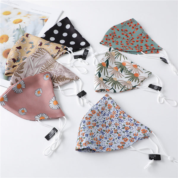 White silk face mask with light blue floral pattern and adjustable ear loops for women's sun protection.