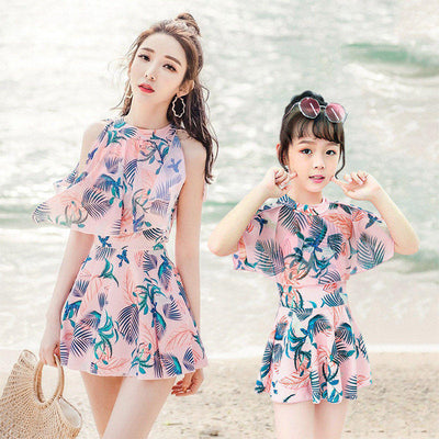 Mother and daughter matching swimsuits with blue and pink tropical leaf print. Adult halter top and skirt, child's ruffle top and skirt. - Image 3