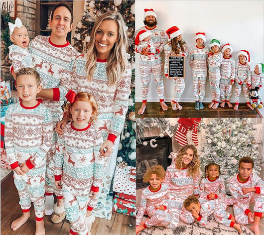Family of four wearing matching green and white Christmas pajamas with fair isle print and red trim, sitting on a bed. - Image 3