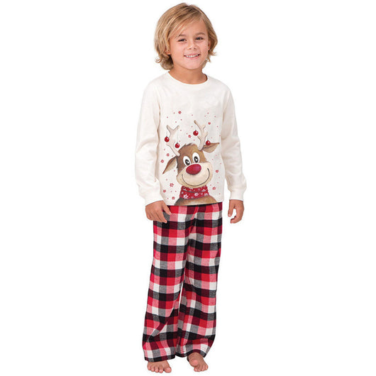 Family of four and a golden retriever wearing matching white long-sleeve reindeer tops and red plaid pajama pants. - Image 17