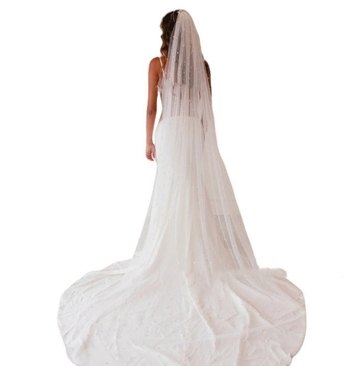 Mid-length white bridal veil with scattered pearl embellishments, flowing elegantly on a mannequin. - Image 10