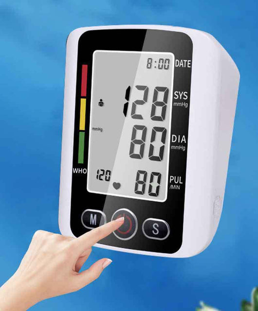 White electronic arm blood pressure monitor with large digital display and dark blue cuff, next to its product box. - Image 16