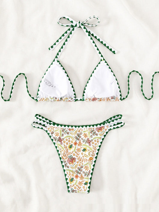 White halter bikini with green rickrack trim and a vibrant floral and bird print, featuring a triangle top and high-cut bottom. - Image 10