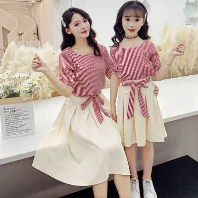 Matching mother and daughter in Korean fashion two-piece suits, featuring red and white striped tops and cream pleated midi skirts. - Image 2
