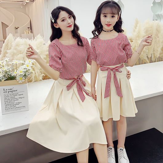 Matching mother and daughter in Korean fashion two-piece suits, featuring red and white striped tops and cream pleated midi skirts. - Image 2