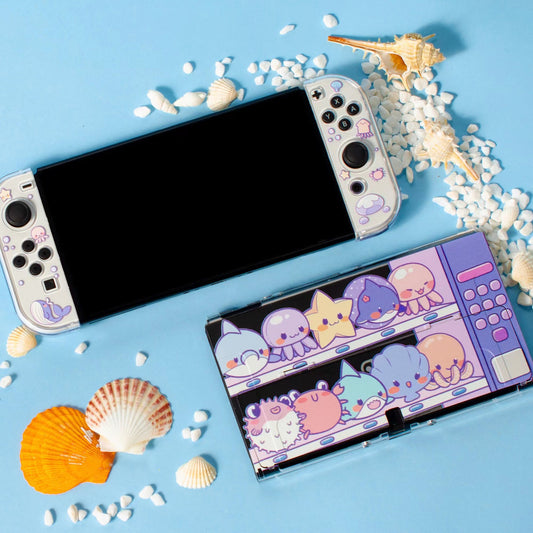 Clear protective case for Nintendo Switch OLED with cute marine animal design, including paw print thumb grips.