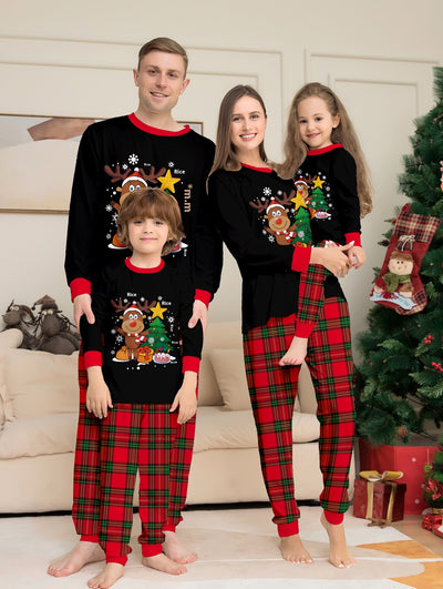 Two children in black and red plaid Christmas pajamas with a reindeer and Christmas tree graphic, standing by a Christmas tree. - Image 14
