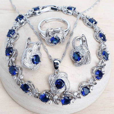 Blue zirconia jewelry set with silver-toned necklace, bracelet, ring, and earrings, featuring swirling designs. - Image 2
