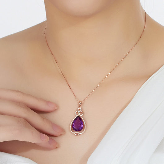 Rose gold necklace with a teardrop purple gemstone pendant and matching dangle earrings.