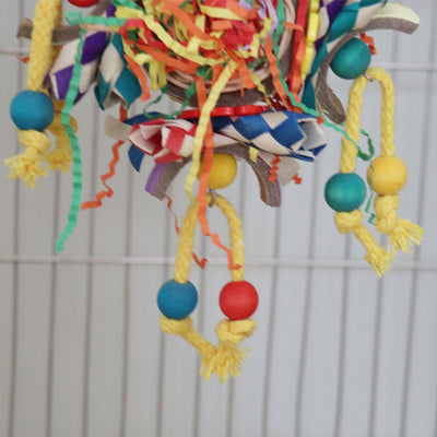 Colorful bird toy with paper tubes, shredded paper, and wooden beads, hanging inside a white wire bird cage. - Image 4
