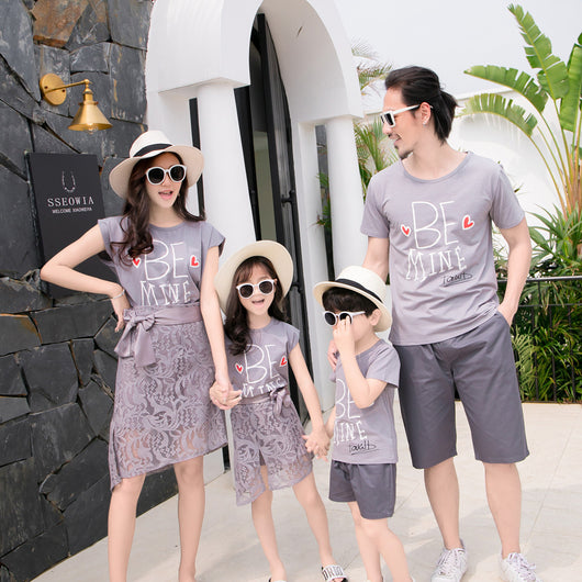 Family of four in matching grey "BE MINE" outfits. Mother and daughter wear lace skirts, father and son wear shorts. - Image 12