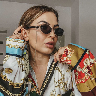 Women's hexagonal sunglasses with dark lenses, gold-colored metal frame, black temples, and a detachable gold chain. - Image 8