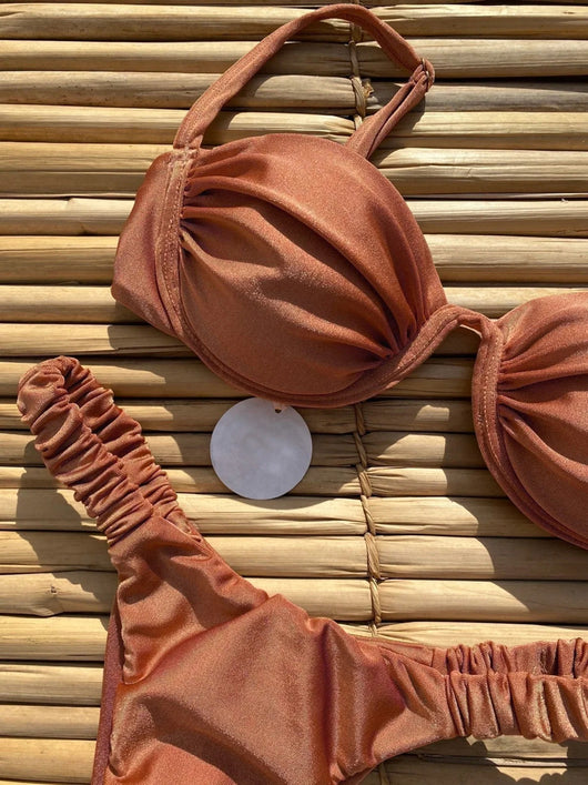 Rust underwire bikini set with ruched top and high-cut bottom, displayed on a woven mat. - Image 19