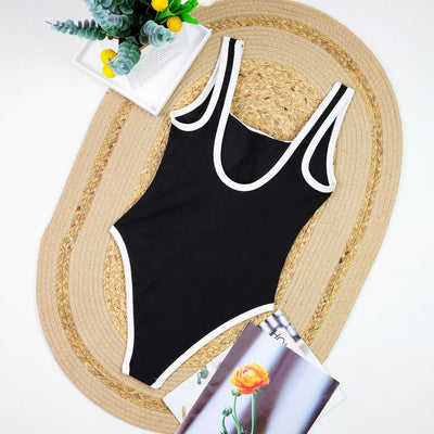 Woman in a white one-piece swimsuit with black trim and decorative buttons, sitting on a boat. - Image 20