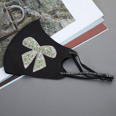 Black ear-mounted mask with a sparkling rhinestone bow pattern, featuring adjustable ear loops. - Image 17