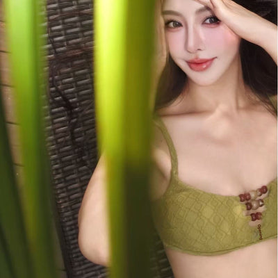 Olive green two-piece bikini with textured fabric and decorative wooden beads on the top and bottom, modeled by a woman. - Image 2