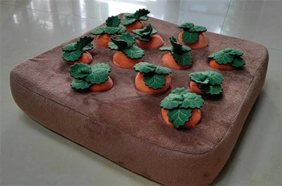 Brown plush snuffle mat with ten orange carrot-shaped toys, each with green leafy tops, for pet foraging and play. - Image 19