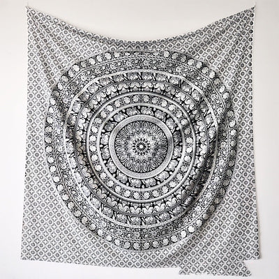 Black and white mandala tapestry with string lights hanging above a bed with blue and white patterned pillows. - Image 5
