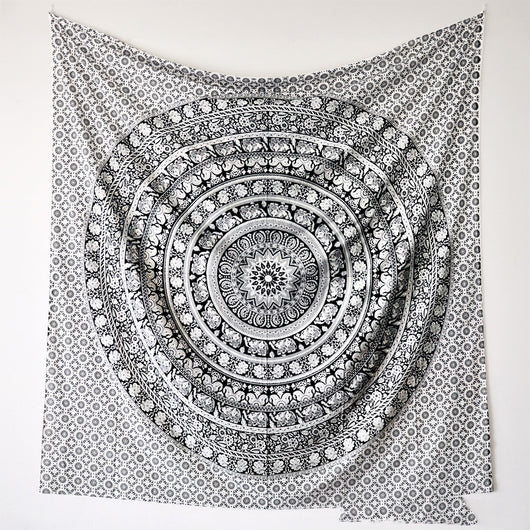 Black and white mandala tapestry with string lights hanging above a bed with blue and white patterned pillows. - Image 5