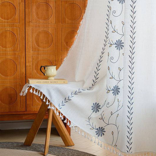 White semi-sheer curtain with brown botanical embroidery and white tassels, draped over a small wooden table. - Image 7