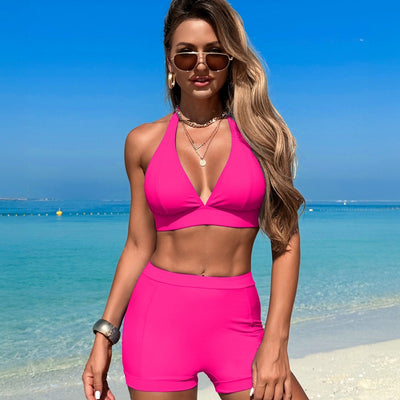 Woman in a hot pink halter neck bikini top and matching high-waisted swim shorts at the beach. - Image 3