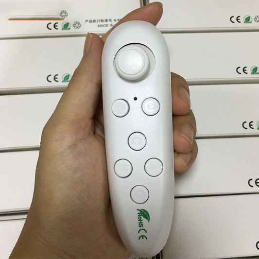 White Bluetooth remote control gamepad with joystick and multiple buttons, held in a hand.