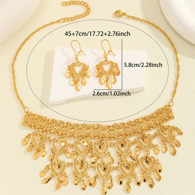 Gold heart-shaped hollow necklace and matching dangle earrings set on a woman wearing a black top. - Image 6