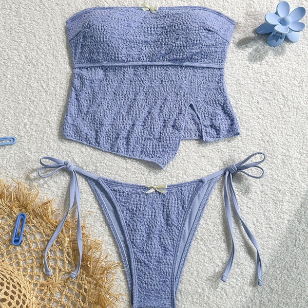 Light blue textured two-piece bikini with a strapless top and high-cut bottom with side ties and white bows.