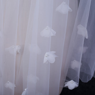 White and ivory sheer fabric swatches for a wedding veil displayed on green grass. - Image 11