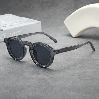 Vintage round frame sunglasses with black frames and pink lenses on a gray surface. - Image 4
