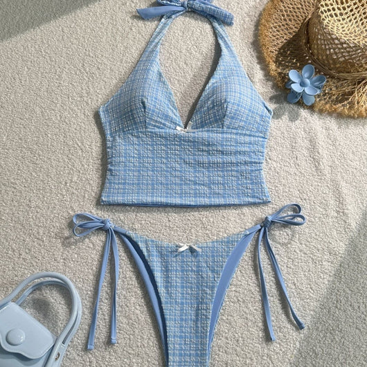 Light blue textured plaid two-piece swimsuit with a halter top and side-tie bikini bottoms, featuring small white bows.