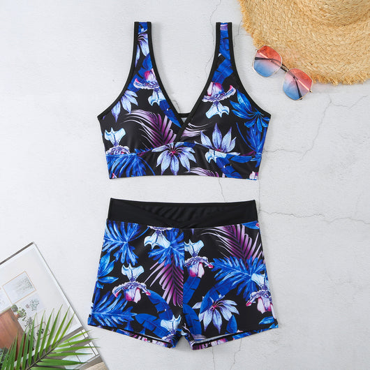 Two-piece swimsuit with a black background and vibrant pink and purple tropical floral print. Features a V-neck crop top and high-waisted boxer shorts. - Image 7