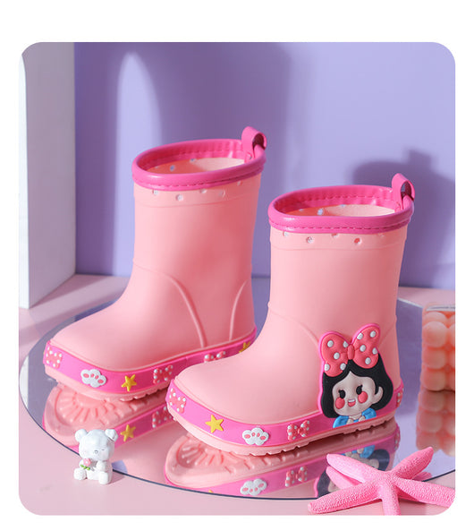 Bright yellow children's rain boots with a green cartoon dinosaur design and orange trim, held by hands. - Image 22