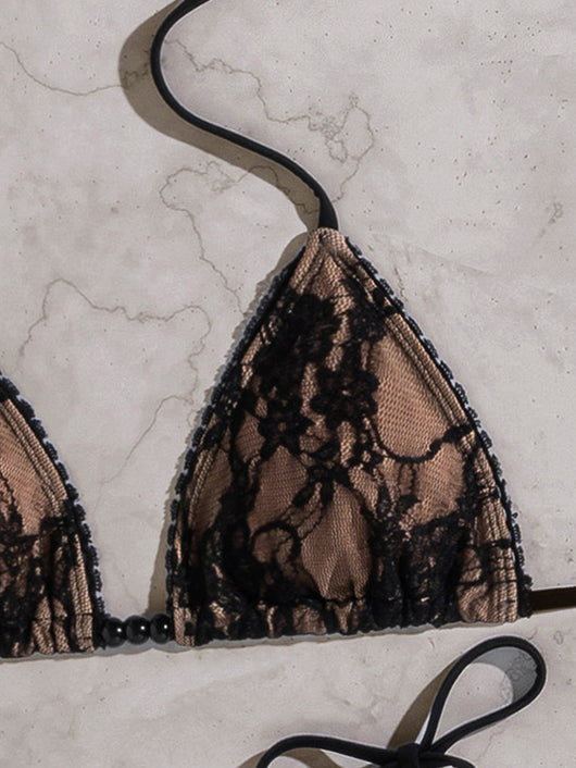 Black lace triangle-cup tie-front bikini swimsuit with nude lining, shown flat on a light marble surface. - Image 16