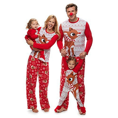 Family of five wearing matching red and white Christmas pajamas with reindeer and snowflake patterns.