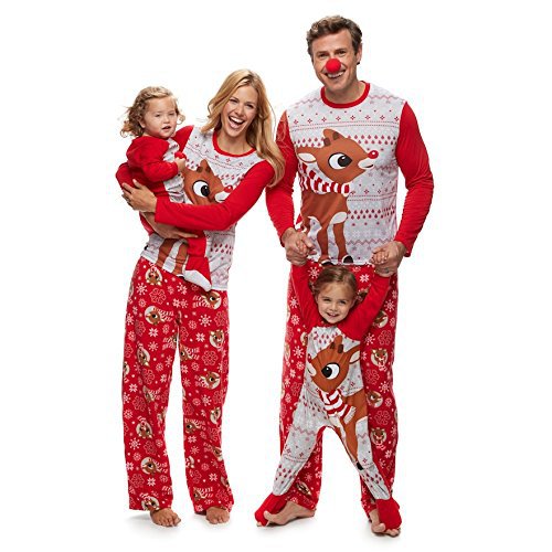 Family of five wearing matching red and white Christmas pajamas with reindeer and snowflake patterns.