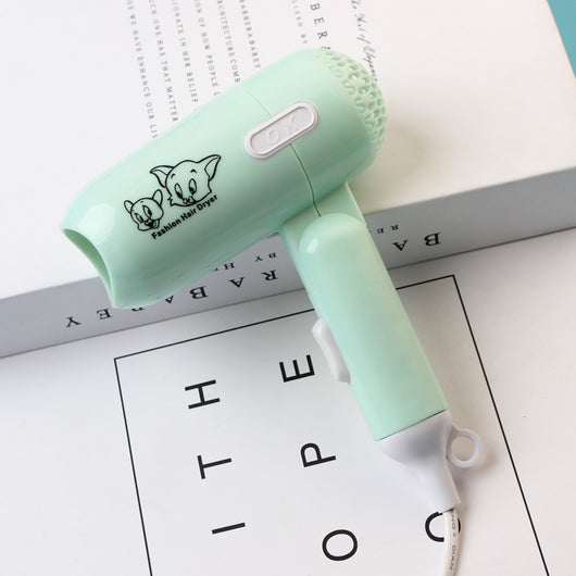 Light blue foldable hair dryer with a cartoon pig design, white power switch, and hanging loop. - Image 7