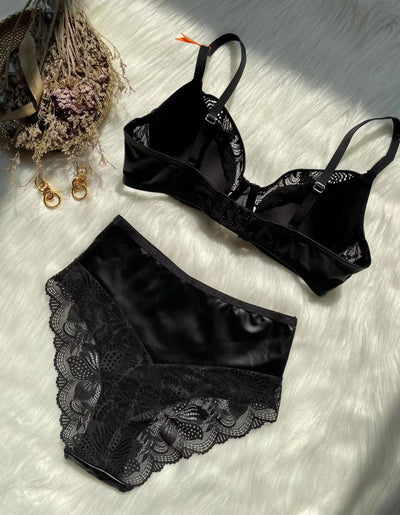 Black lace and smooth fabric bra and matching panties set, featuring a decorative ring, on a white faux fur surface. - Image 19