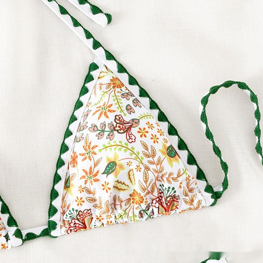 White halter bikini with green rickrack trim and a vibrant floral and bird print, featuring a triangle top and high-cut bottom. - Image 3