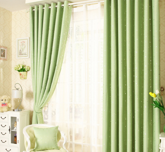 Blue star print curtains tied back to reveal sheer white curtains, in a bright room with a white chair. - Image 11