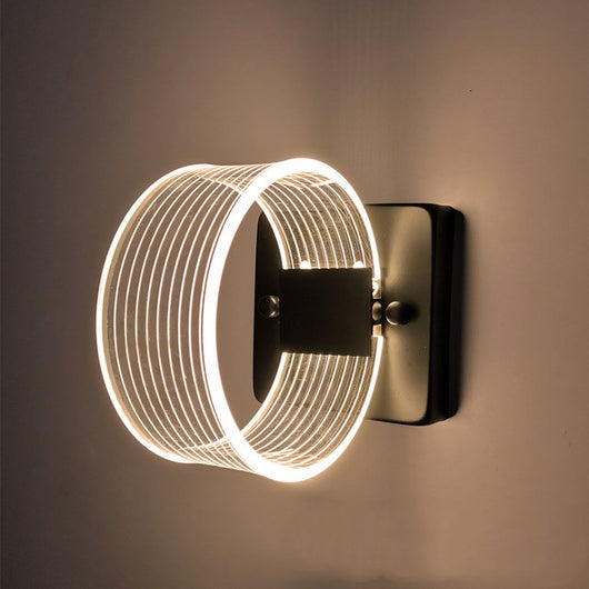 Modern simple LED wall lamp with a curved clear acrylic shade and a metallic base, emitting a warm light. - Image 14