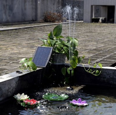 5W solar fountain kit with black solar panel on a ground stake, water pump, coiled hose, and various nozzles. - Image 22