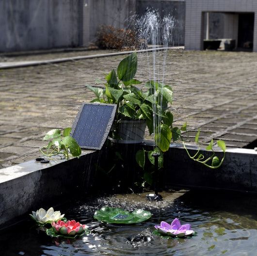 5W solar fountain kit with black solar panel on a ground stake, water pump, coiled hose, and various nozzles. - Image 22