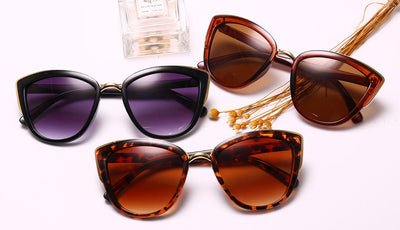Black cat-eye sunglasses for women with gradient grey lenses and subtle gold-tone metal accents on the frame. - Image 3